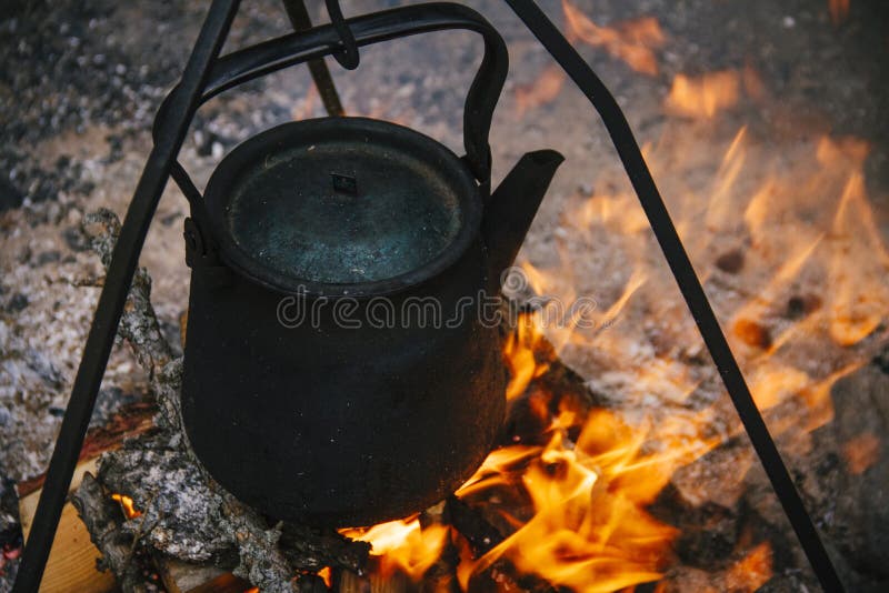 De oude ketel brandt bij de staak, koken de toeristen water op de brand Brandkampvuur en het koken in de campagne royalty-vrije stock foto's De oude ketel brandt bij de staak, koken de toeristen water op de brand Brandkampvuur en het koken in de campagne royalty-vrije stock foto's