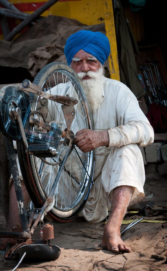 De oude mens Sikh herstelt de cyclus stock fotografie De oude mens Sikh herstelt de cyclus stock fotografie