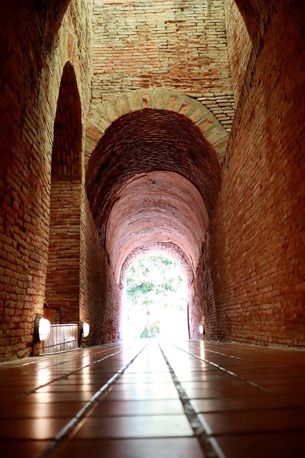 De oude tunnel met een licht in het eind in Wat Umong Changmai Thailand stock foto's De oude tunnel met een licht in het eind in Wat Umong Changmai Thailand stock foto's