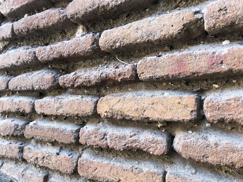 De oude uitstekende middeleeuwse middeleeuwse stoffige authentieke bruine baksteen van de texturensteen met naden op een bakstene stock afbeelding De oude uitstekende middeleeuwse middeleeuwse stoffige authentieke bruine baksteen van de texturensteen met naden op een bakstene stock afbeelding