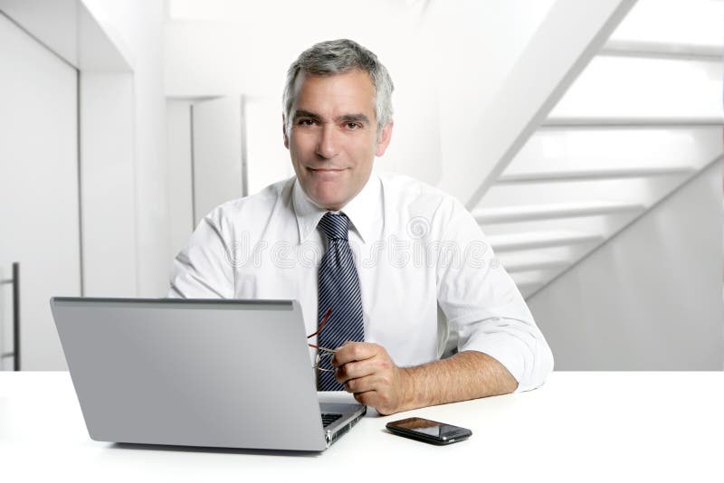 De oudste die van de zakenman binnenlands modern bureau werkt royalty-vrije stock afbeeldingen De oudste die van de zakenman binnenlands modern bureau werkt royalty-vrije stock afbeeldingen