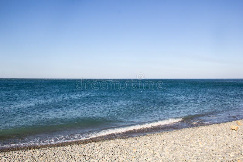 De overzeese schuimende golven op een leeg kiezelsteenstrand royalty-vrije stock afbeeldingen De overzeese schuimende golven op een leeg kiezelsteenstrand royalty-vrije stock afbeeldingen