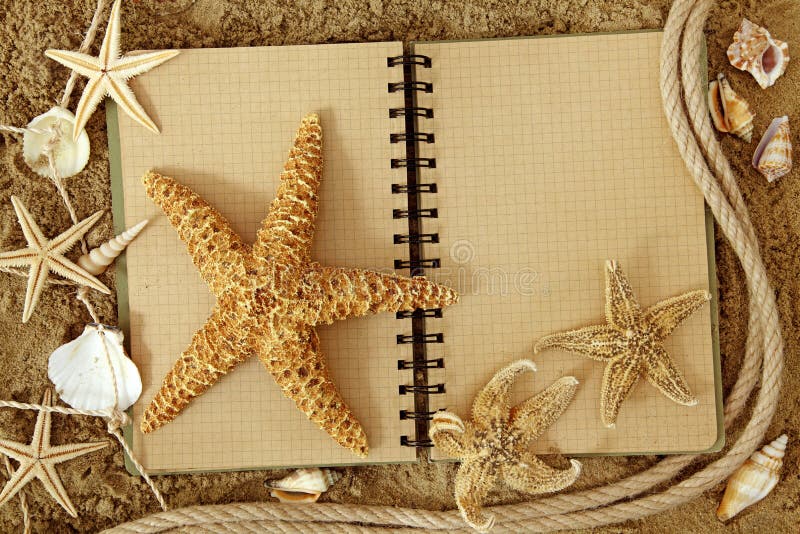 Exercise book and sea stars on sand. Exercise book and sea stars on sand