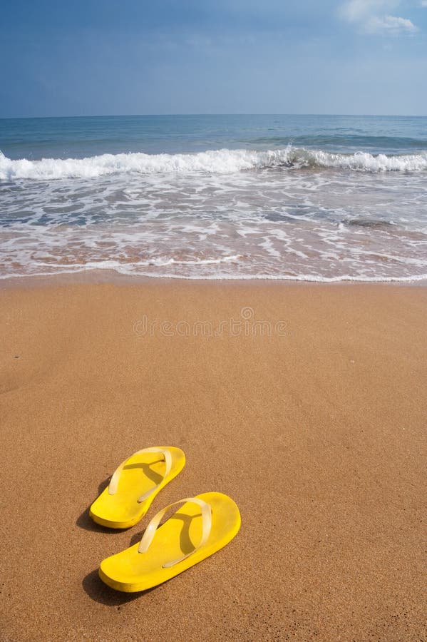 De pantoffels van het strand op zandig strand royalty-vrije stock afbeeldingen De pantoffels van het strand op zandig strand royalty-vrije stock afbeeldingen