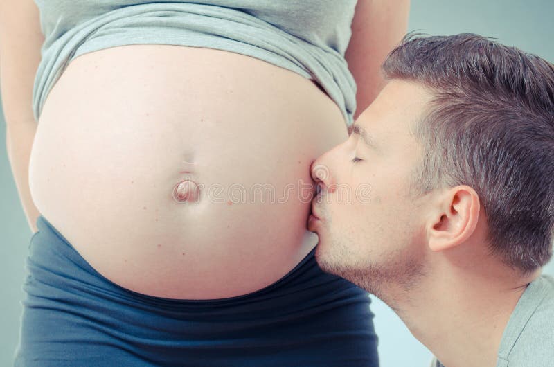 De papa kust zijn zwangere vrouw royalty-vrije stock afbeelding De papa kust zijn zwangere vrouw royalty-vrije stock afbeelding