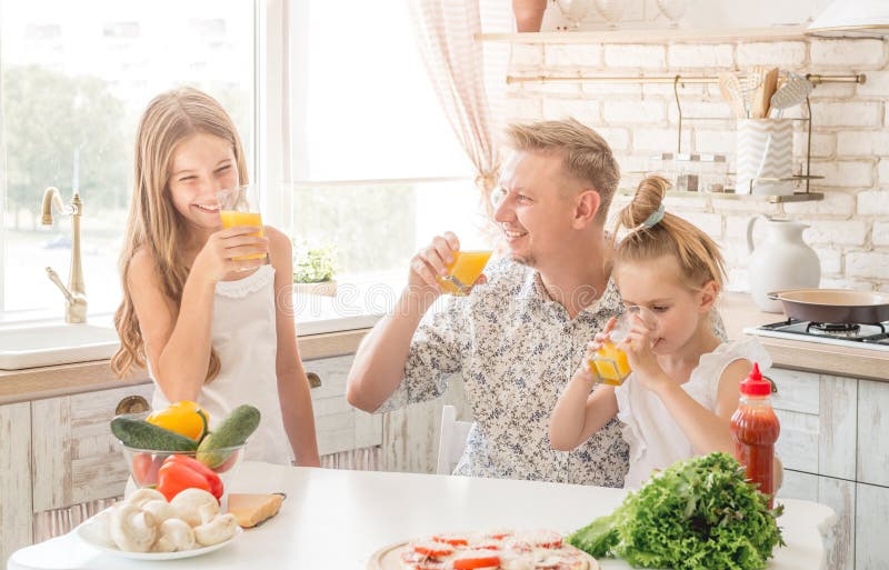 De papa met twee dochters drinkt sap stock foto De papa met twee dochters drinkt sap stock foto