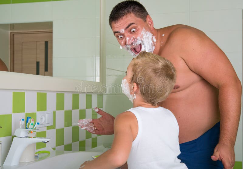 De papa onderwijst om haar te scheren weinig zoon Het kind wil als papa zijn stock afbeelding De papa onderwijst om haar te scheren weinig zoon Het kind wil als papa zijn stock afbeelding