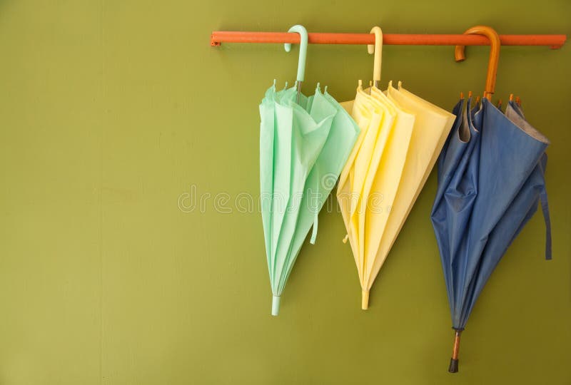 Umbrella hang on hanger /on green wall. Umbrella hang on hanger /on green wall