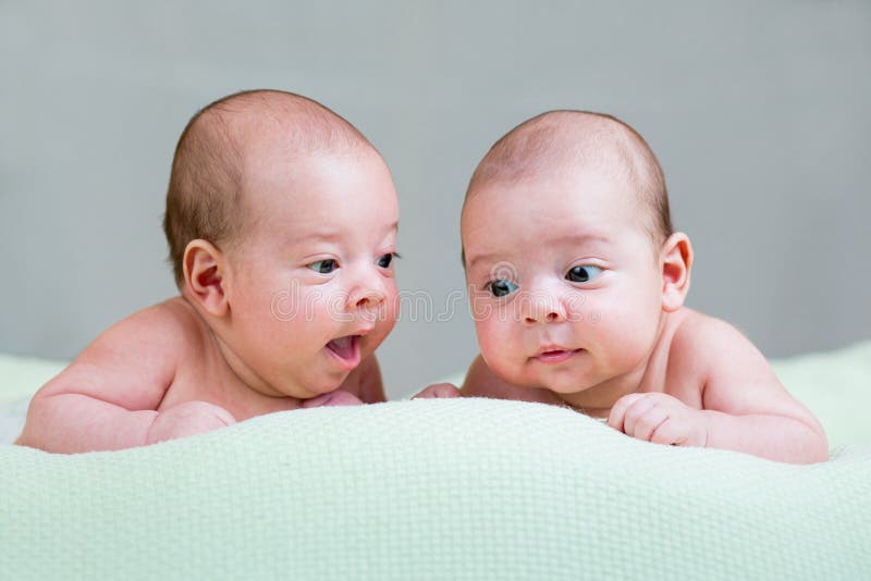 De pasgeboren baby brengt jongens samen liggend op maag stock afbeelding De pasgeboren baby brengt jongens samen liggend op maag stock afbeelding