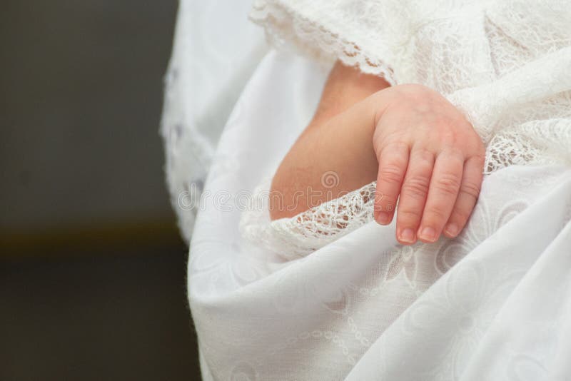 De pasgeboren hand van het babymeisje op kleren witte als achtergrond stock afbeelding De pasgeboren hand van het babymeisje op kleren witte als achtergrond stock afbeelding