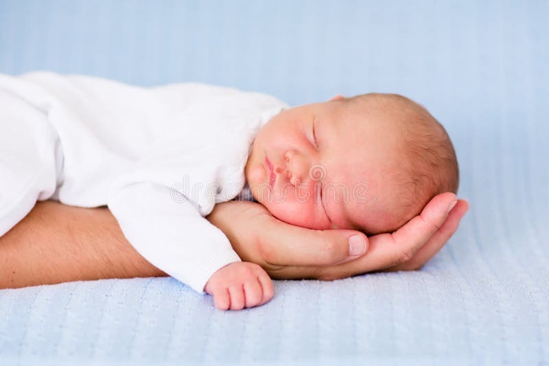 De pasgeboren slaap van de babyjongen op de hand van zijn vader royalty-vrije stock afbeelding De pasgeboren slaap van de babyjongen op de hand van zijn vader royalty-vrije stock afbeelding