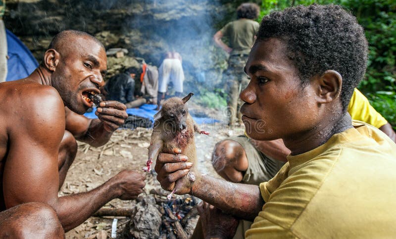 De plaatselijke bewoners papuan van het eiland Nieuw-Guinea hebben diner de gevangen vleerhond royalty-vrije stock fotografie De plaatselijke bewoners papuan van het eiland Nieuw-Guinea hebben diner de gevangen vleerhond royalty-vrije stock fotografie