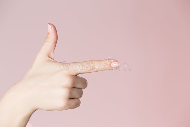 De plaatsthema van de schoonheidssalon Vrouwenhand met roze manicure die kanonteken tonen royalty-vrije stock foto De plaatsthema van de schoonheidssalon Vrouwenhand met roze manicure die kanonteken tonen royalty-vrije stock foto