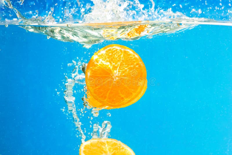 De plak van de citrusvrucht het BESPATTEN IN WATER royalty-vrije stock foto De plak van de citrusvrucht het BESPATTEN IN WATER royalty-vrije stock foto