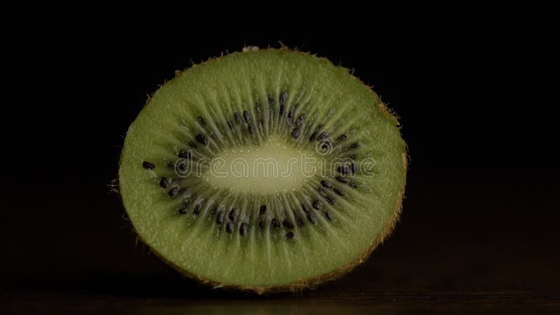 De plak van het kiwifruit in extreme dichte omhooggaande voorraadlengte Een plak van Kiwifruit in macro dichte omhooggaand met ee stock foto De plak van het kiwifruit in extreme dichte omhooggaande voorraadlengte Een plak van Kiwifruit in macro dichte omhooggaand met ee stock foto