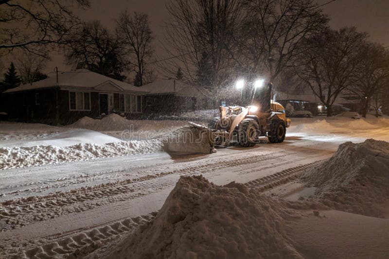 De ploegende vrachtwagen die van de de dienstsneeuw woonstraat tijdens zware sneeuwstorm, Toronto, Ontario, Canada schoonmaken