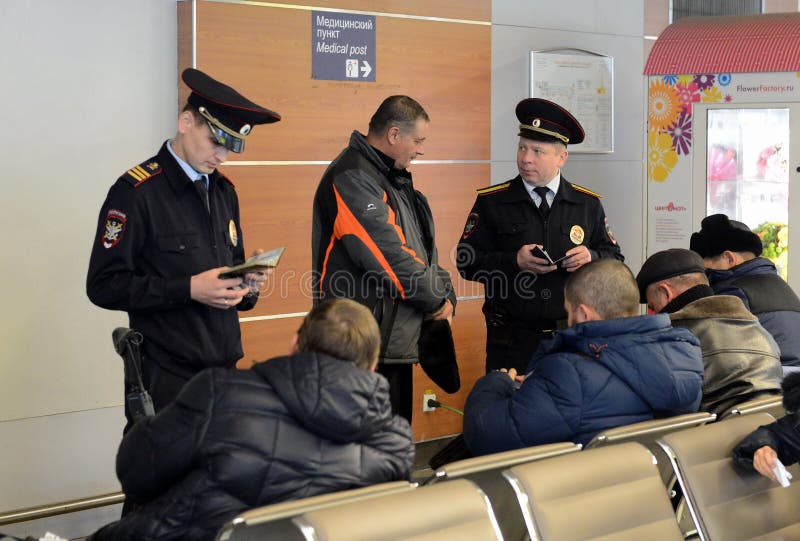 De politieagenten van het vervoer controleren de passagiersdocumenten op de internationale luchthaven Sheremetyevo in Moskou royalty-vrije stock foto's De politieagenten van het vervoer controleren de passagiersdocumenten op de internationale luchthaven Sheremetyevo in Moskou royalty-vrije stock foto's