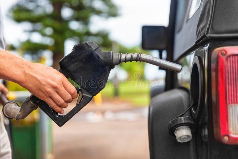 De pomp van het benzinestation Het vullen van de mens benzinebrandstof in de pijp van de autoholding stock fotografie De pomp van het benzinestation Het vullen van de mens benzinebrandstof in de pijp van de autoholding stock fotografie