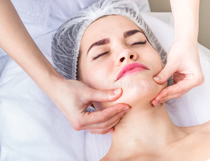 De professionele lymphodrainage gezichtsmassage cosmetologist raakt de cliënt` s kin royalty-vrije stock foto's De professionele lymphodrainage gezichtsmassage cosmetologist raakt de cliënt` s kin royalty-vrije stock foto's