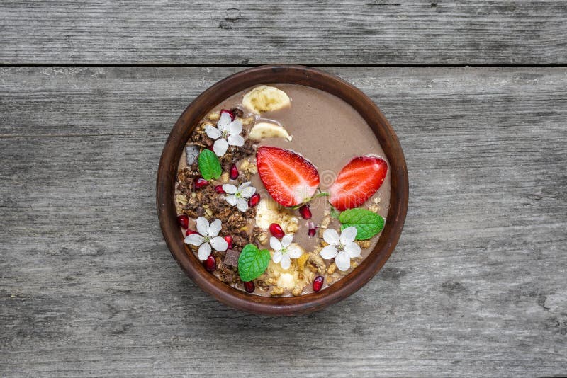 De proteïne van de cacaobanaan smoothie werpt met van de van de chocoladegranola, aardbei en granaatappel zaden met bloemen worde royalty-vrije stock afbeeldingen De proteïne van de cacaobanaan smoothie werpt met van de van de chocoladegranola, aardbei en granaatappel zaden met bloemen worde royalty-vrije stock afbeeldingen