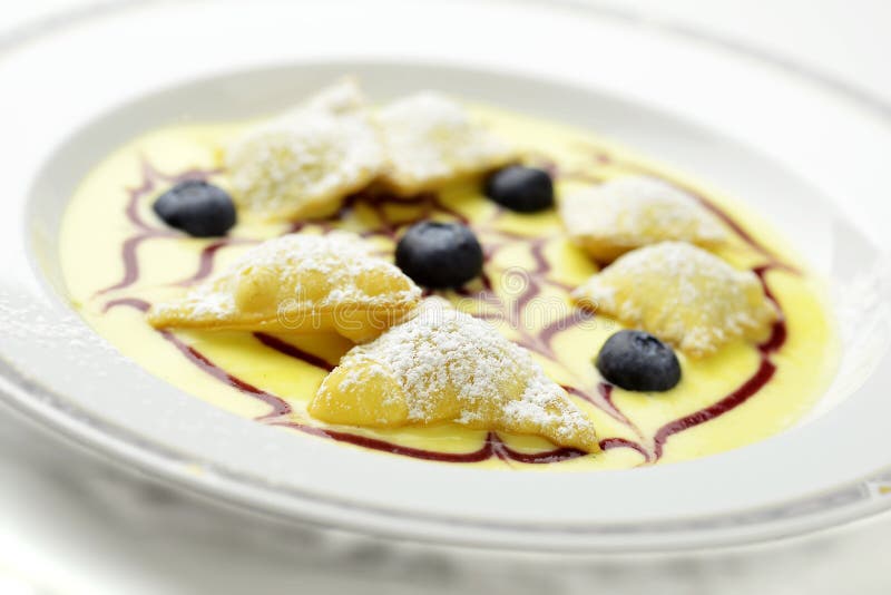 De ravioli van het dessertfruit op Engelse vla royalty-vrije stock afbeelding De ravioli van het dessertfruit op Engelse vla royalty-vrije stock afbeelding