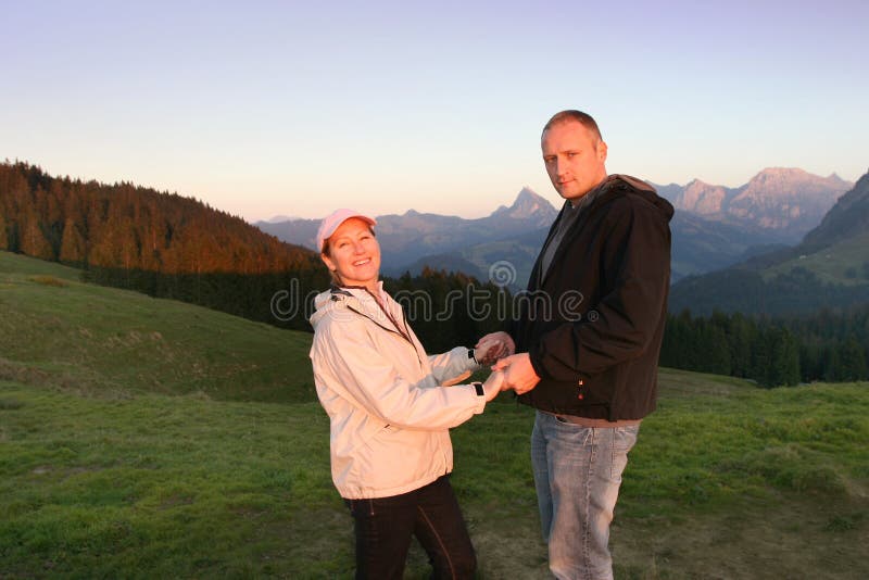 Swiss Alps, the couple relax in the evenings sunrays. Swiss Alps, the couple relax in the evenings sunrays