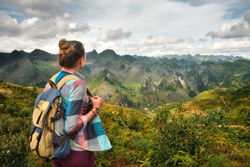 De reiziger die van de Hipstervrouw met rugzak van mooie mening genieten van stock afbeelding De reiziger die van de Hipstervrouw met rugzak van mooie mening genieten van stock afbeelding