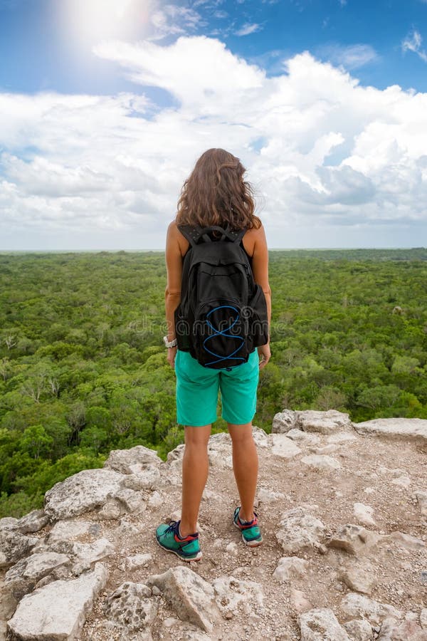 De reizigersvrouw geniet van de mening vanaf de bovenkant van de piramide van Nohoch Mul in Coba royalty-vrije stock afbeelding De reizigersvrouw geniet van de mening vanaf de bovenkant van de piramide van Nohoch Mul in Coba royalty-vrije stock afbeelding