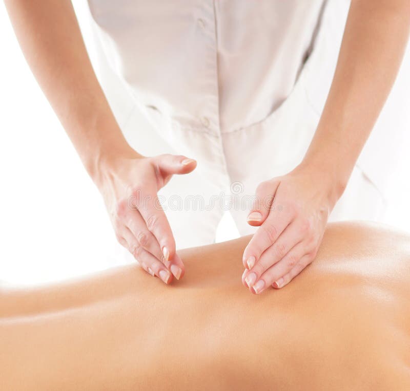 Back of a young and fit woman and hands on a massage procedure. The image is taken on a white background. Back of a young and fit woman and hands on a massage procedure. The image is taken on a white background.