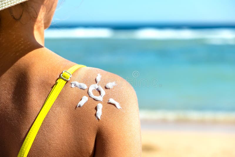 de retour vue de jeune femme se bronzant à la plage avec de la crème