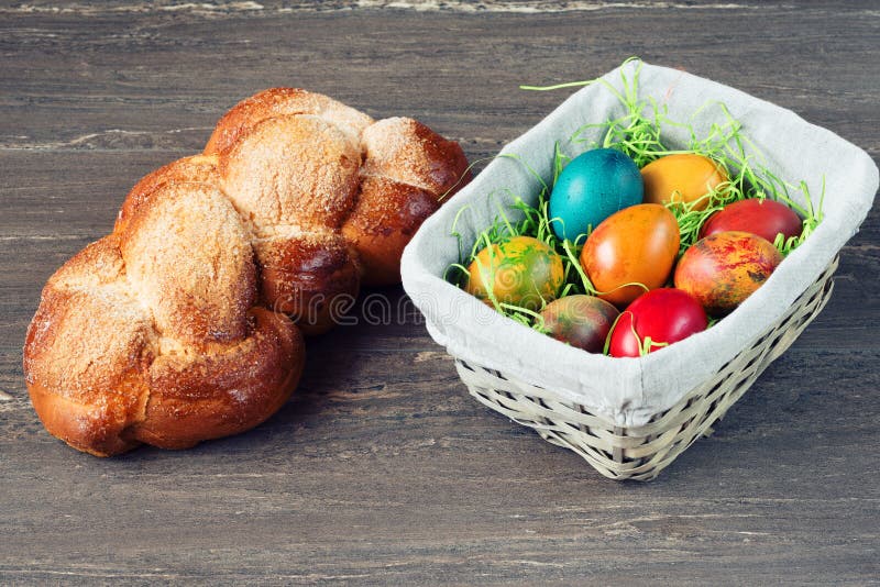 De rieten mand van Pasen met gekleurde eieren en Pasen-brood op grijze houten raad royalty-vrije stock foto's De rieten mand van Pasen met gekleurde eieren en Pasen-brood op grijze houten raad royalty-vrije stock foto's