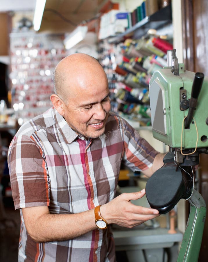 De rijpe laarzen van het werkmans naaiende leer op steekdraaibank stock fotografie De rijpe laarzen van het werkmans naaiende leer op steekdraaibank stock fotografie