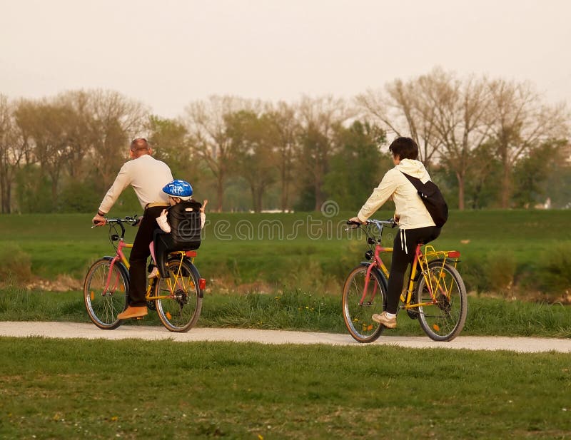 Family bike ride down the river shore promenade. Family bike ride down the river shore promenade