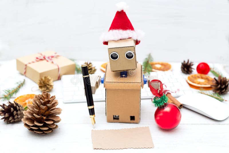 De robot schreef een kaart van de Kerstmisgroet en houdt een Kerstboom stock afbeeldingen De robot schreef een kaart van de Kerstmisgroet en houdt een Kerstboom stock afbeeldingen