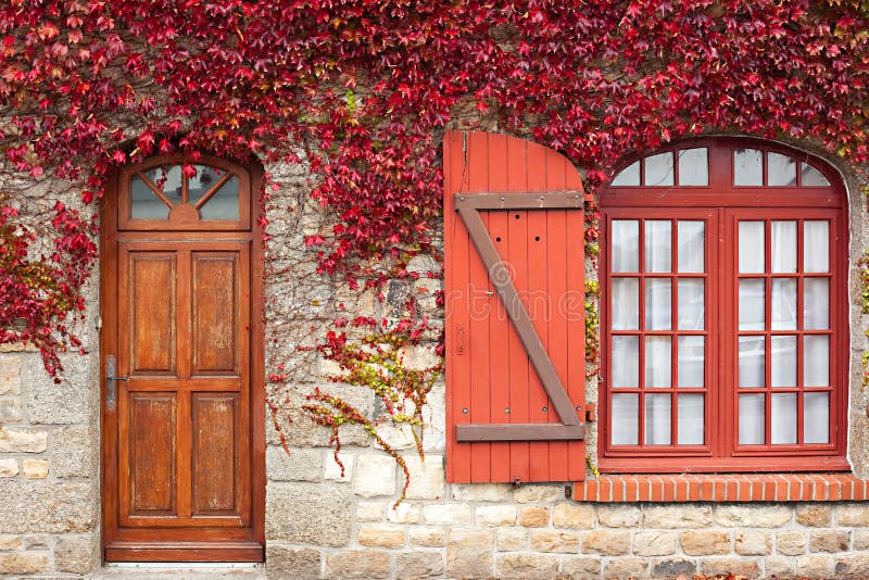 De rode wijnstok van de herfst op huis royalty-vrije stock afbeelding De rode wijnstok van de herfst op huis royalty-vrije stock afbeelding