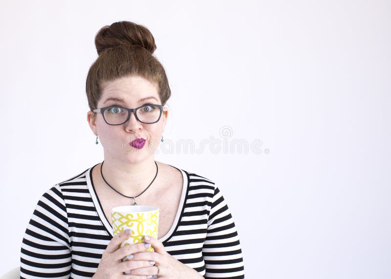 Expressive millennial woman with red hair and black and white striped top communicates non-verbally. Expressive millennial woman with red hair and black and white striped top communicates non-verbally