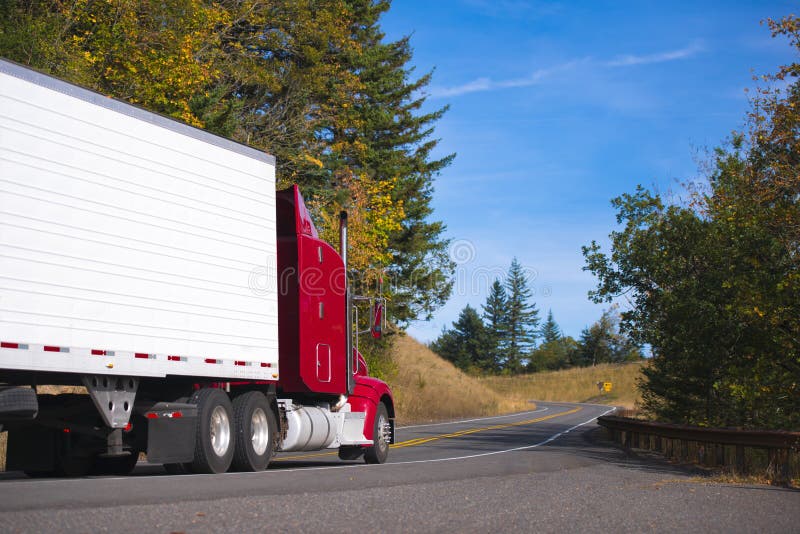 De rouge installation et remorque de camion semi sur la route compliquée d'automne photographie stock De rouge installation et remorque de camion semi sur la route compliquée d'automne photographie stock