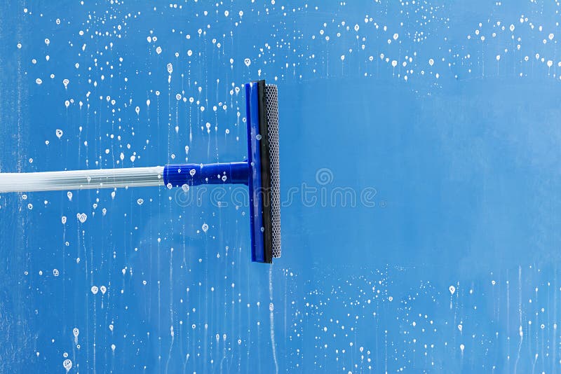 De rubberrubberschuiver maakt venster schoon Ontruimt een streep van ingezeept venster Het schoonmaken de dienstconcept stock foto De rubberrubberschuiver maakt venster schoon Ontruimt een streep van ingezeept venster Het schoonmaken de dienstconcept stock foto