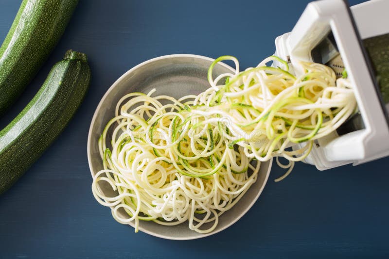 De ruwe groente van de Spiralizingscourgette met spiralizer royalty-vrije stock afbeeldingen De ruwe groente van de Spiralizingscourgette met spiralizer royalty-vrije stock afbeeldingen