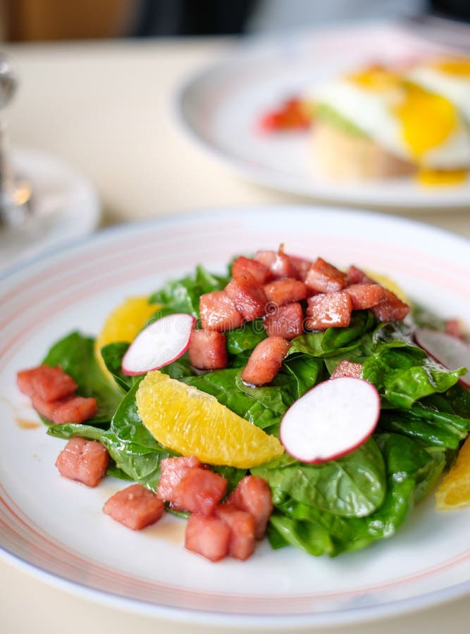De salade van de babyspinazie met sinaasappel, radijsplakken en gedobbelde ham royalty-vrije stock afbeeldingen De salade van de babyspinazie met sinaasappel, radijsplakken en gedobbelde ham royalty-vrije stock afbeeldingen