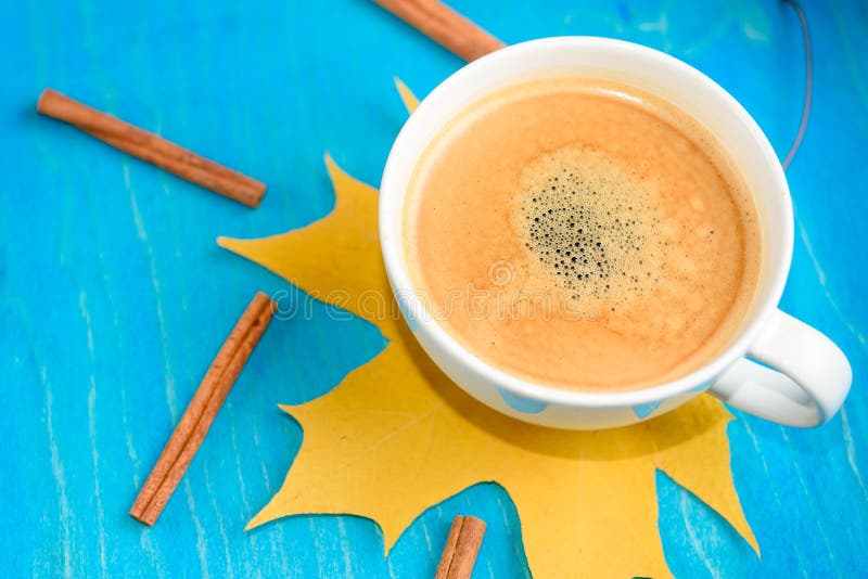 De samenstelling van de de herfstkoffie, koffiekop met schuim, kaneel, de herfstblad bij blauwe achtergrond Dalings hete dranken, royalty-vrije stock foto's De samenstelling van de de herfstkoffie, koffiekop met schuim, kaneel, de herfstblad bij blauwe achtergrond Dalings hete dranken, royalty-vrije stock foto's