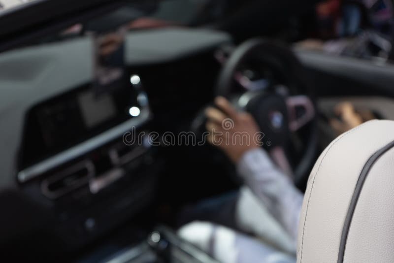 De samenvatting vertroebelde voor achtergrondafbeelding op een mens die in een luxeauto drijven, selectieve nadruk op voorzetel K stock afbeelding De samenvatting vertroebelde voor achtergrondafbeelding op een mens die in een luxeauto drijven, selectieve nadruk op voorzetel K stock afbeelding