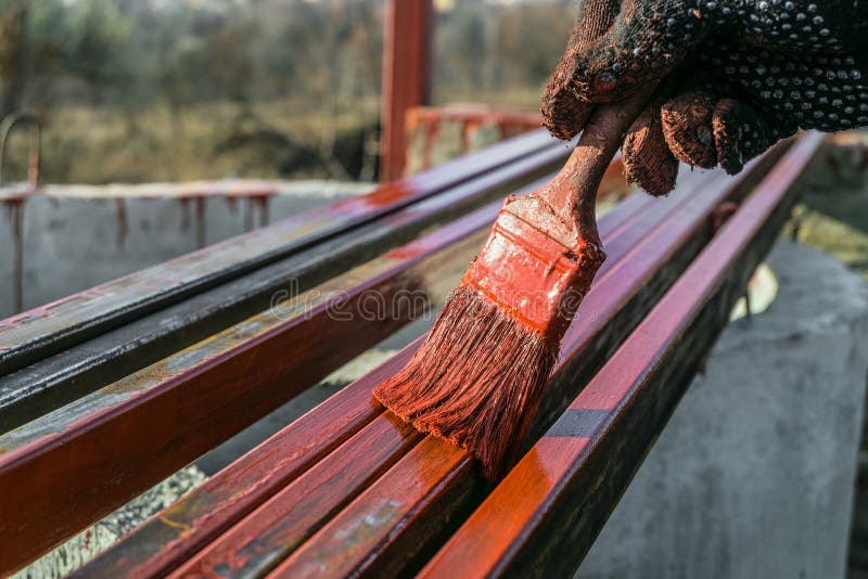 De schilder schildert metaalstructuren Beschermende deklaag van staal gesloten profielen met het rood van het inleidingsijzeroxid royalty-vrije stock foto De schilder schildert metaalstructuren Beschermende deklaag van staal gesloten profielen met het rood van het inleidingsijzeroxid royalty-vrije stock foto