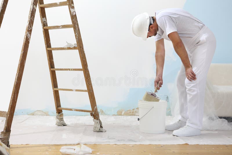 De schildersmens op het werk vergt de kleur met verfborstel van bu stock afbeeldingen De schildersmens op het werk vergt de kleur met verfborstel van bu stock afbeeldingen