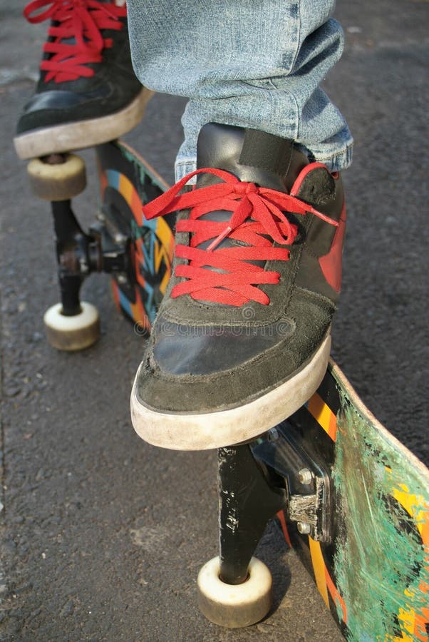 De schoenen, de voeten en de raad van de schaatser stock afbeelding De schoenen, de voeten en de raad van de schaatser stock afbeelding