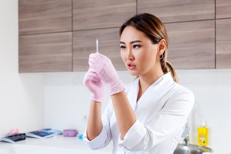 De schoonheidsspecialist duwt een spuit om Botox in te spuiten royalty-vrije stock afbeeldingen De schoonheidsspecialist duwt een spuit om Botox in te spuiten royalty-vrije stock afbeeldingen