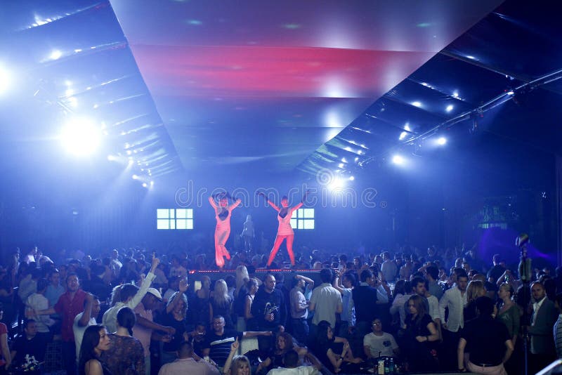 De scène van de nachtclub met dansers en de lichten tonen stock afbeeldingen De scène van de nachtclub met dansers en de lichten tonen stock afbeeldingen