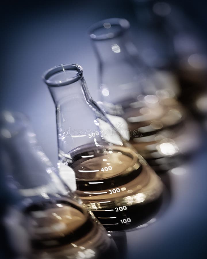 De selectieve flessen van het nadruklaboratorium met gele gouden oplossingen royalty-vrije stock foto De selectieve flessen van het nadruklaboratorium met gele gouden oplossingen royalty-vrije stock foto