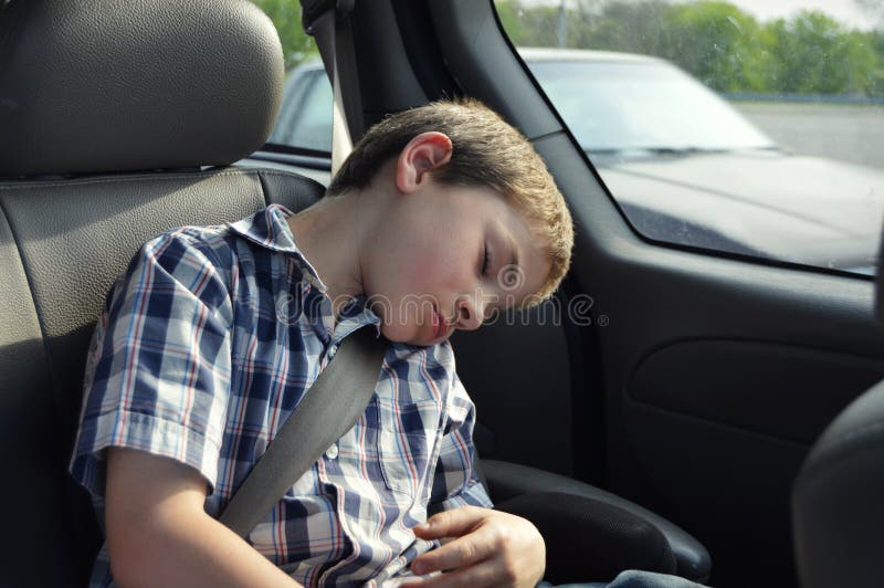 De slaap van de jongen in auto stock afbeelding De slaap van de jongen in auto stock afbeelding