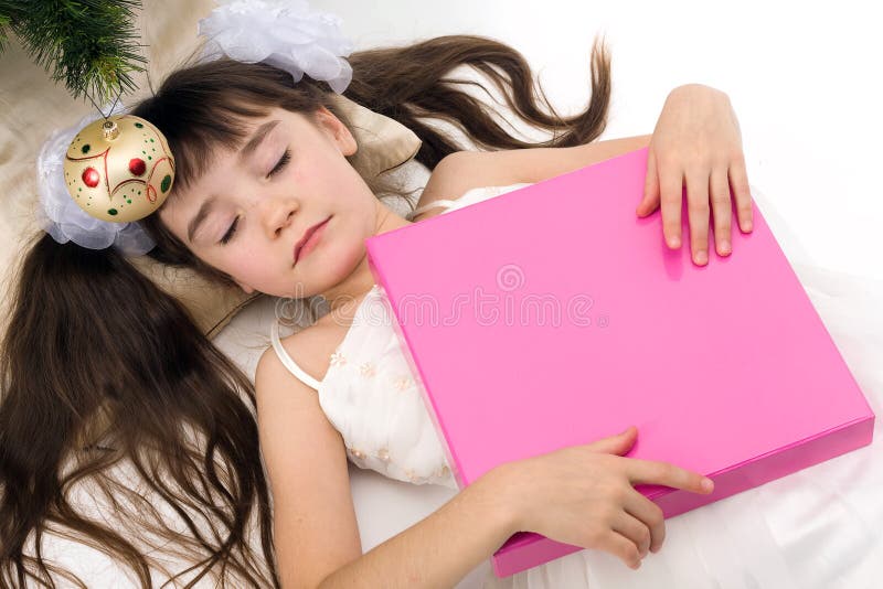 Pretty little girl sleeping under a Christmas tree with present. Pretty little girl sleeping under a Christmas tree with present